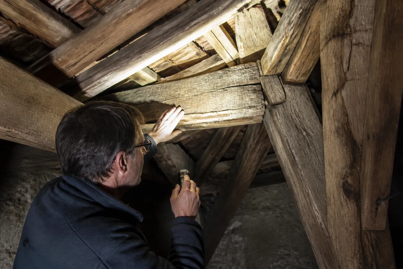 Expert en bâtiment inspectant une charpente ancienne