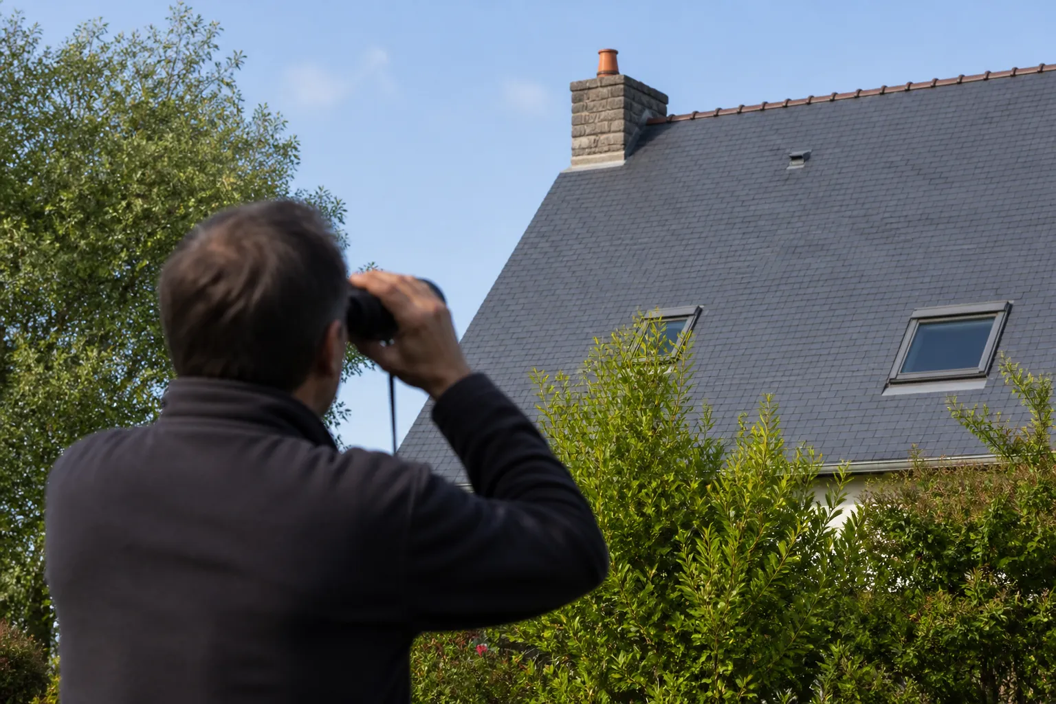 Toiture en ardoise observée depuis le sol par un expert