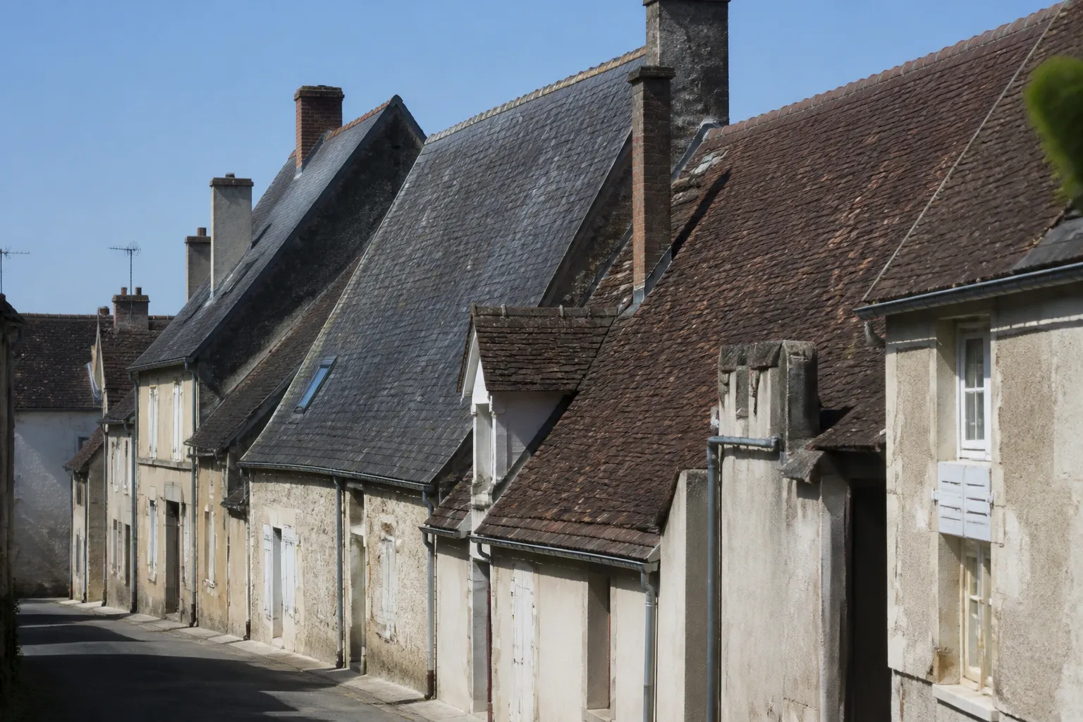 Toiture en petites tuiles plates et ardoises vue depuis le sol