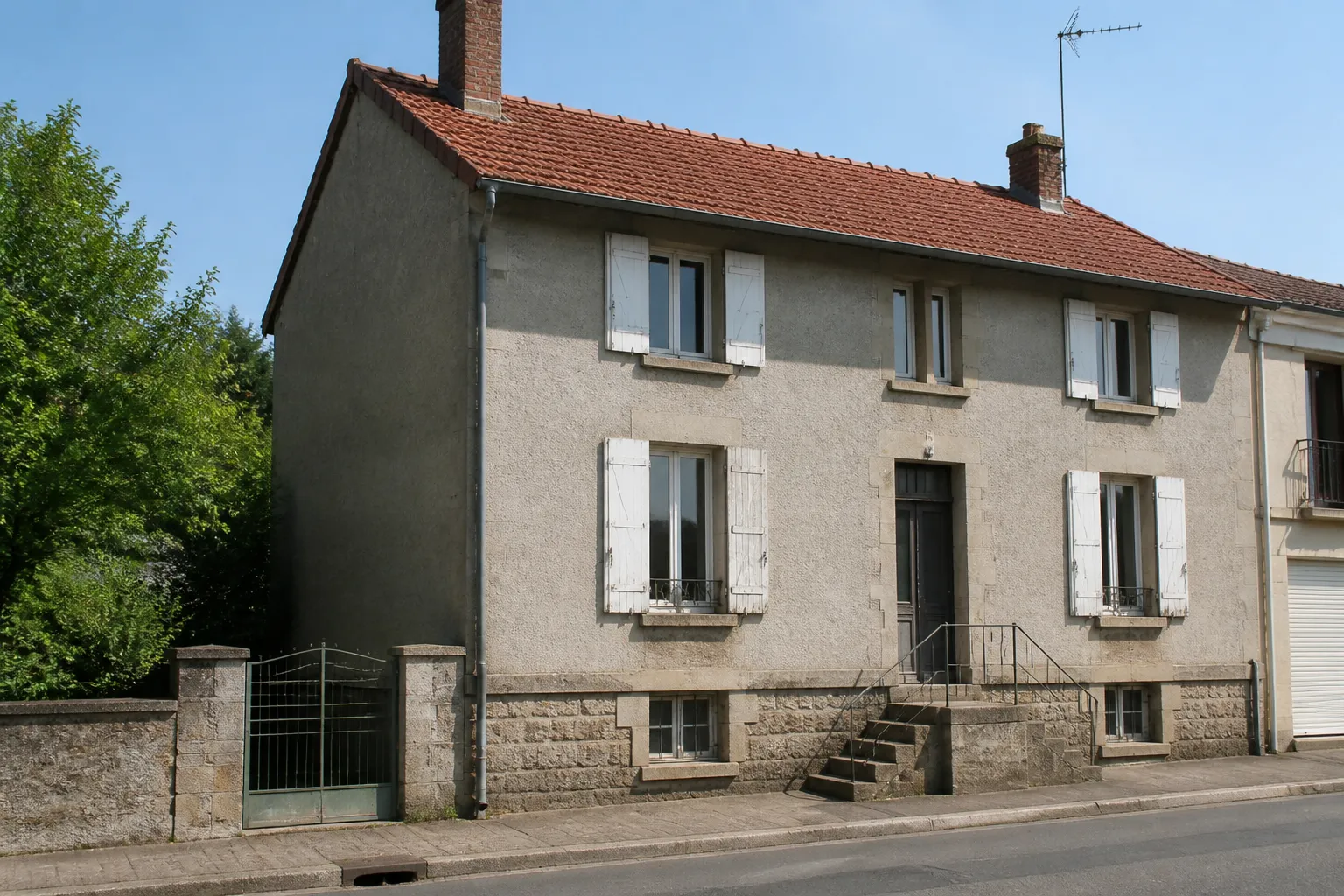 Petit immeuble ouvrier ancien en moellons enduits avec toit de tuiles mécaniques