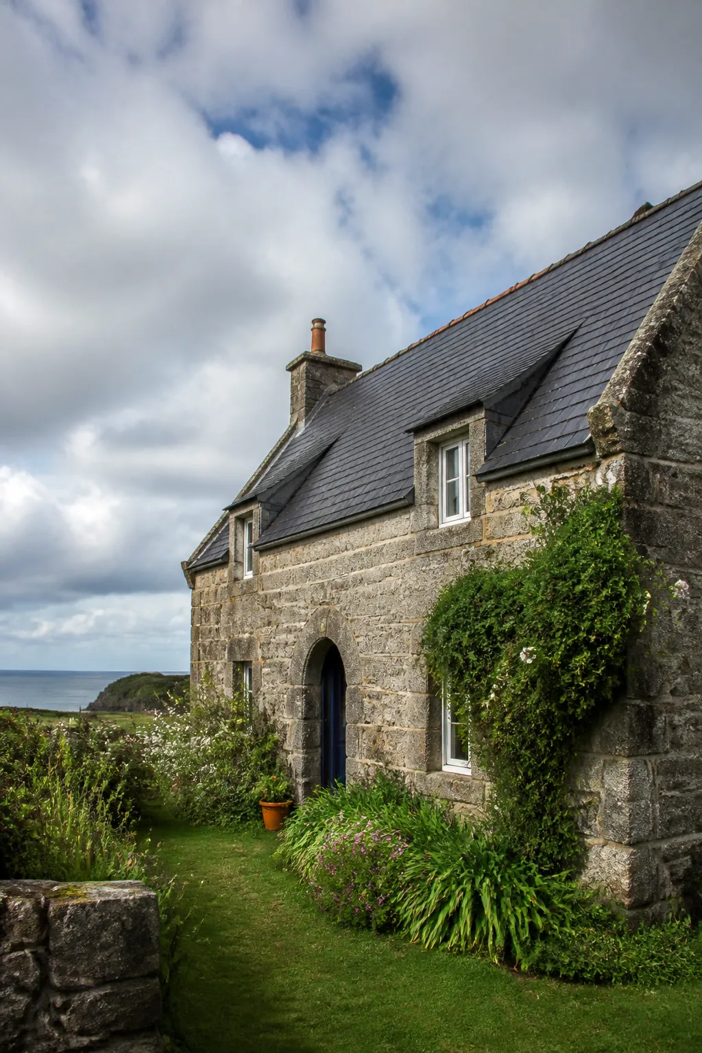 Maison bretonne en granit avec toit d’ardoise près de la côte, observée avant un achat