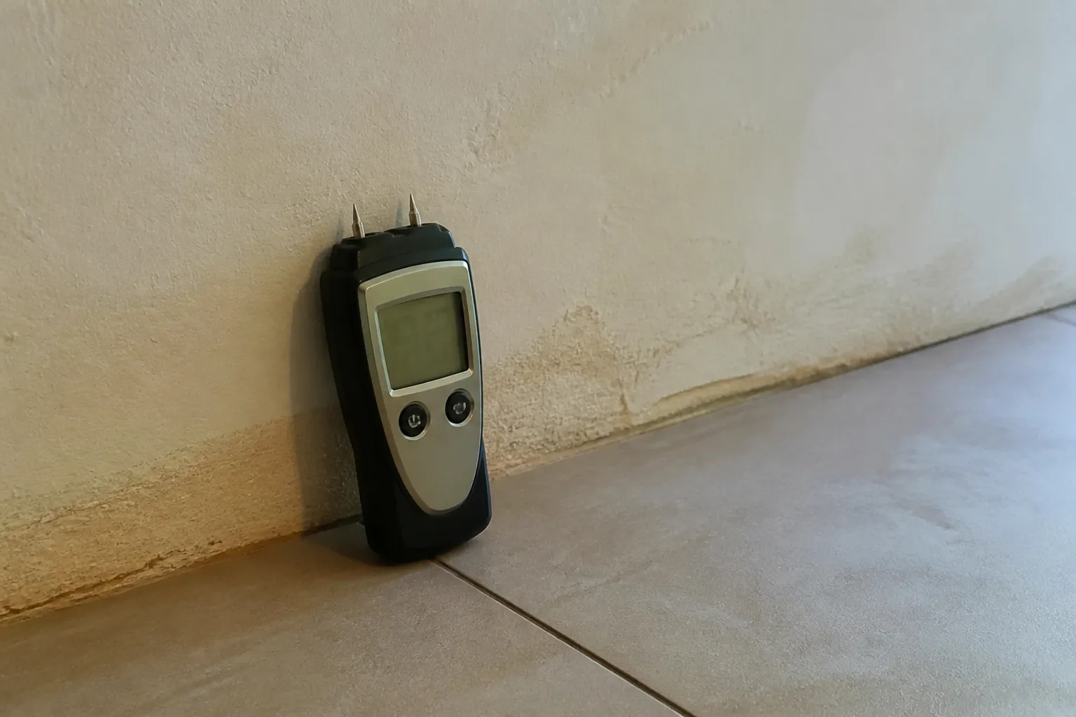 Mesure de l’humidité d’un mur en pied de cloison avec un humidimètre