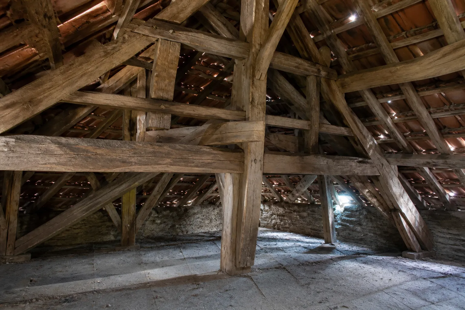 Charpente en bois assemblée par tenons et mortaises dans une maison ancienne