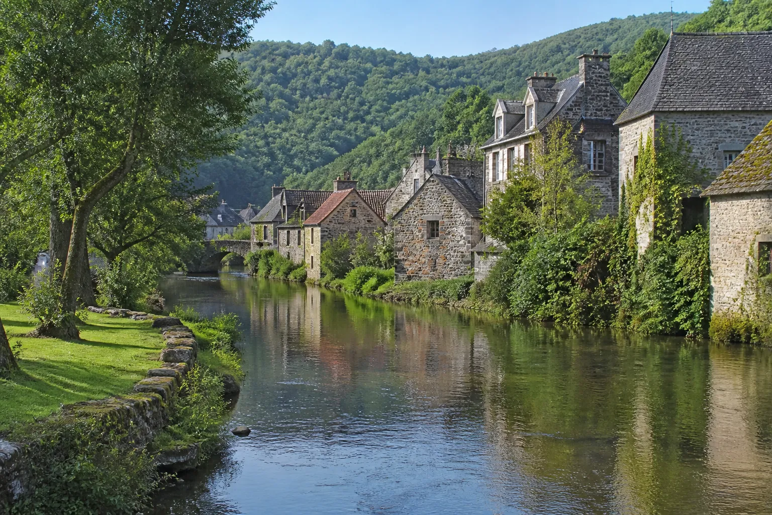 Rivière bordée de maisons anciennes dans une vallée de Haute-Loire