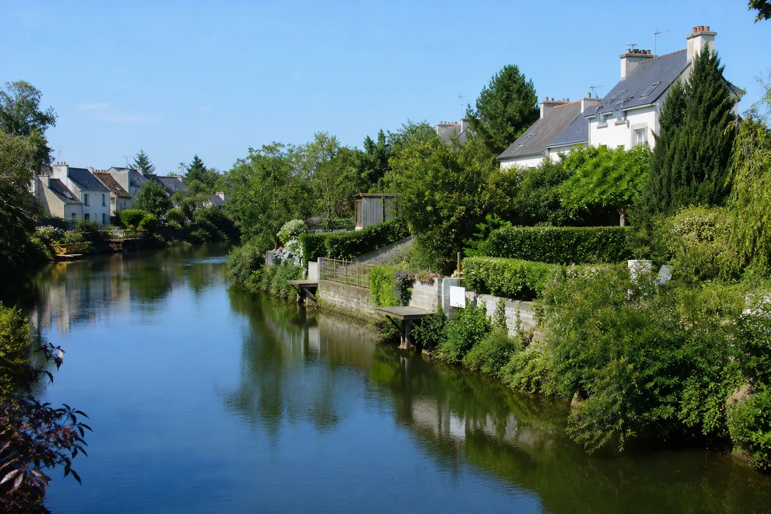 Rivière calme bordée de maisons et de jardins