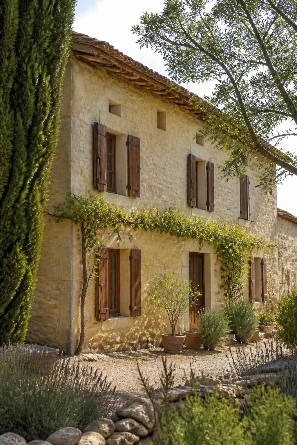 Maison ancienne en pierre calcaire blonde avec toiture en tuiles