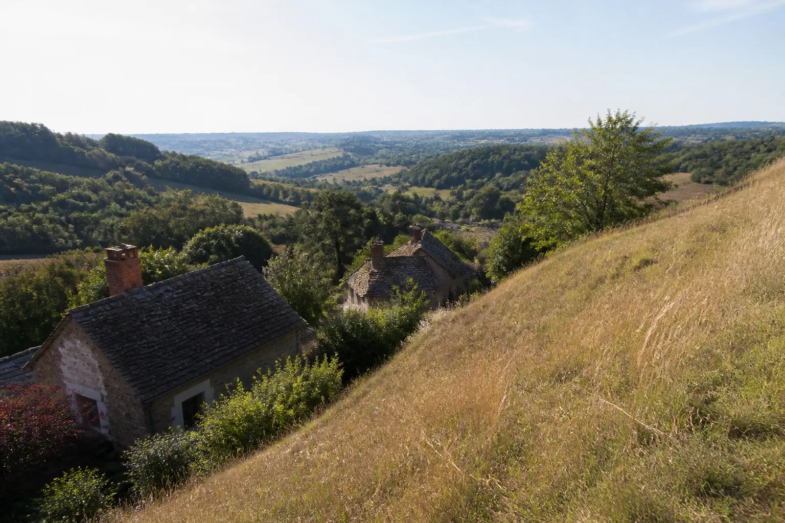 Coteau herbeux avec maisons en contrebas