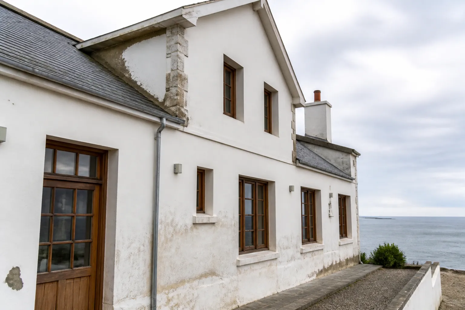 Façade de maison côtière exposée aux embruns