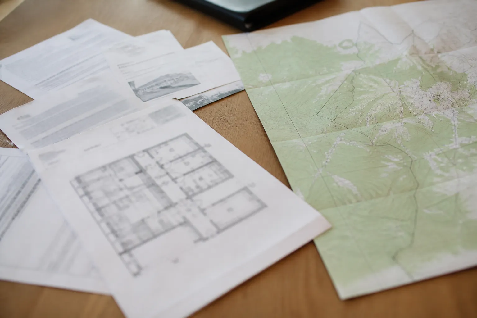 Documents d’achat immobilier et carte posés sur une table