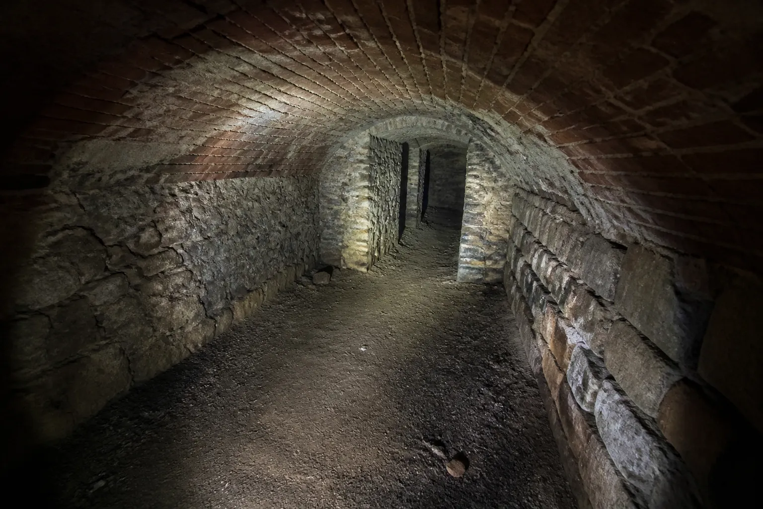 Cave voûtée ancienne examinée avec une lampe torche