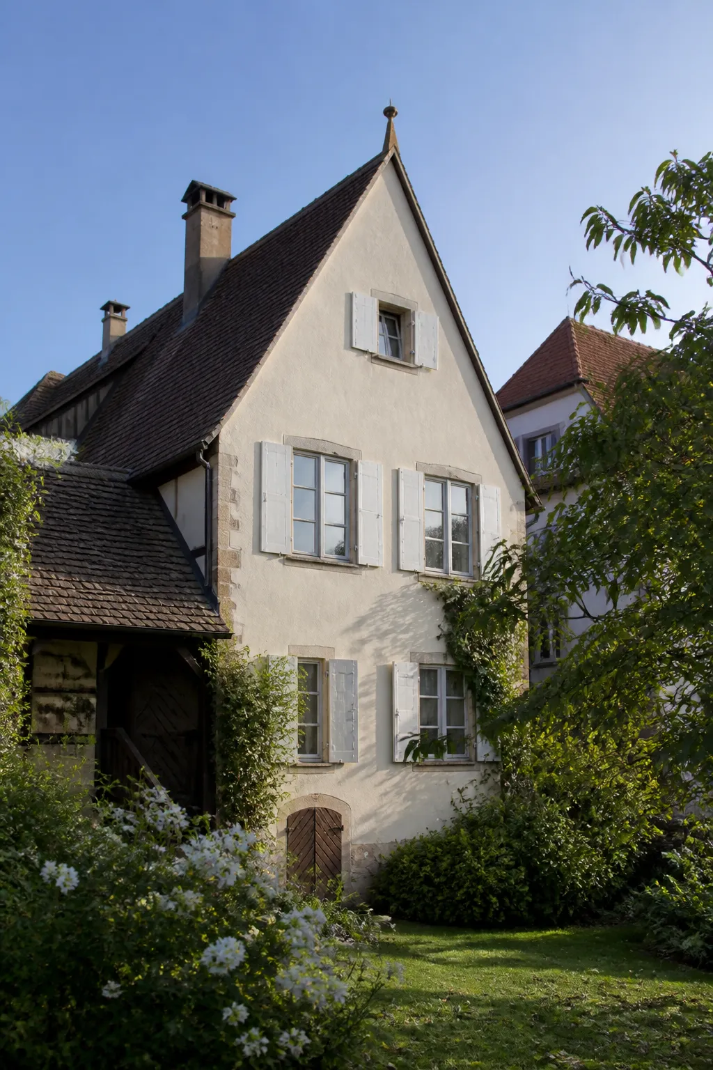 Maison alsacienne ancienne avec façade enduite et toit de tuiles dans le Haut-Rhin