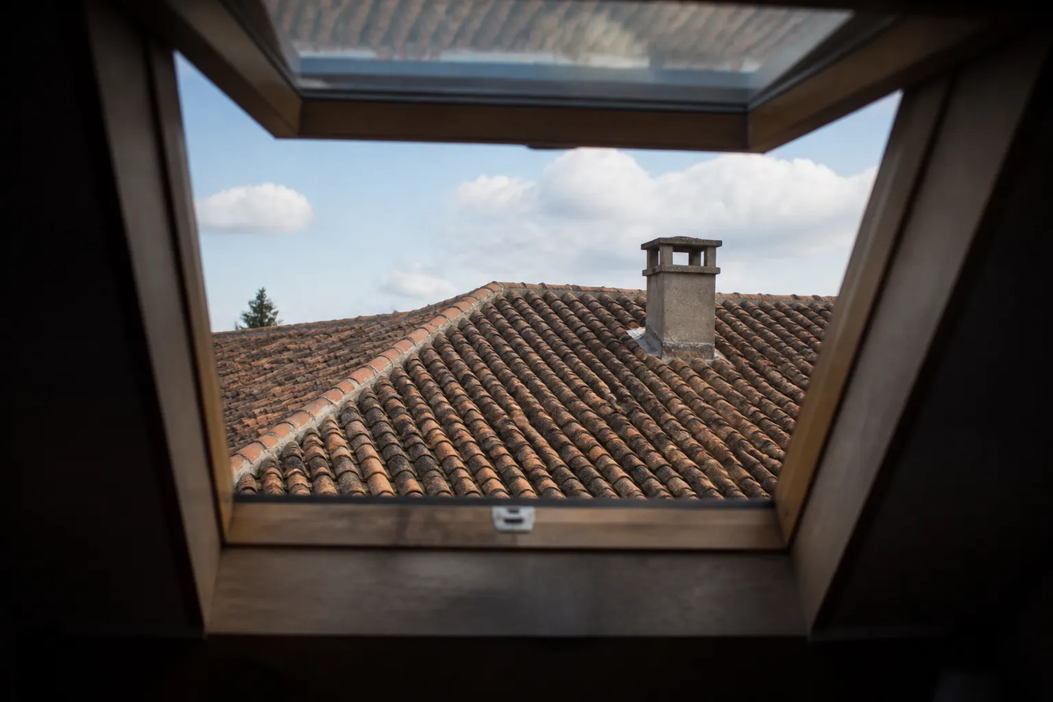 Toiture de tuiles vue depuis une fenêtre de combles