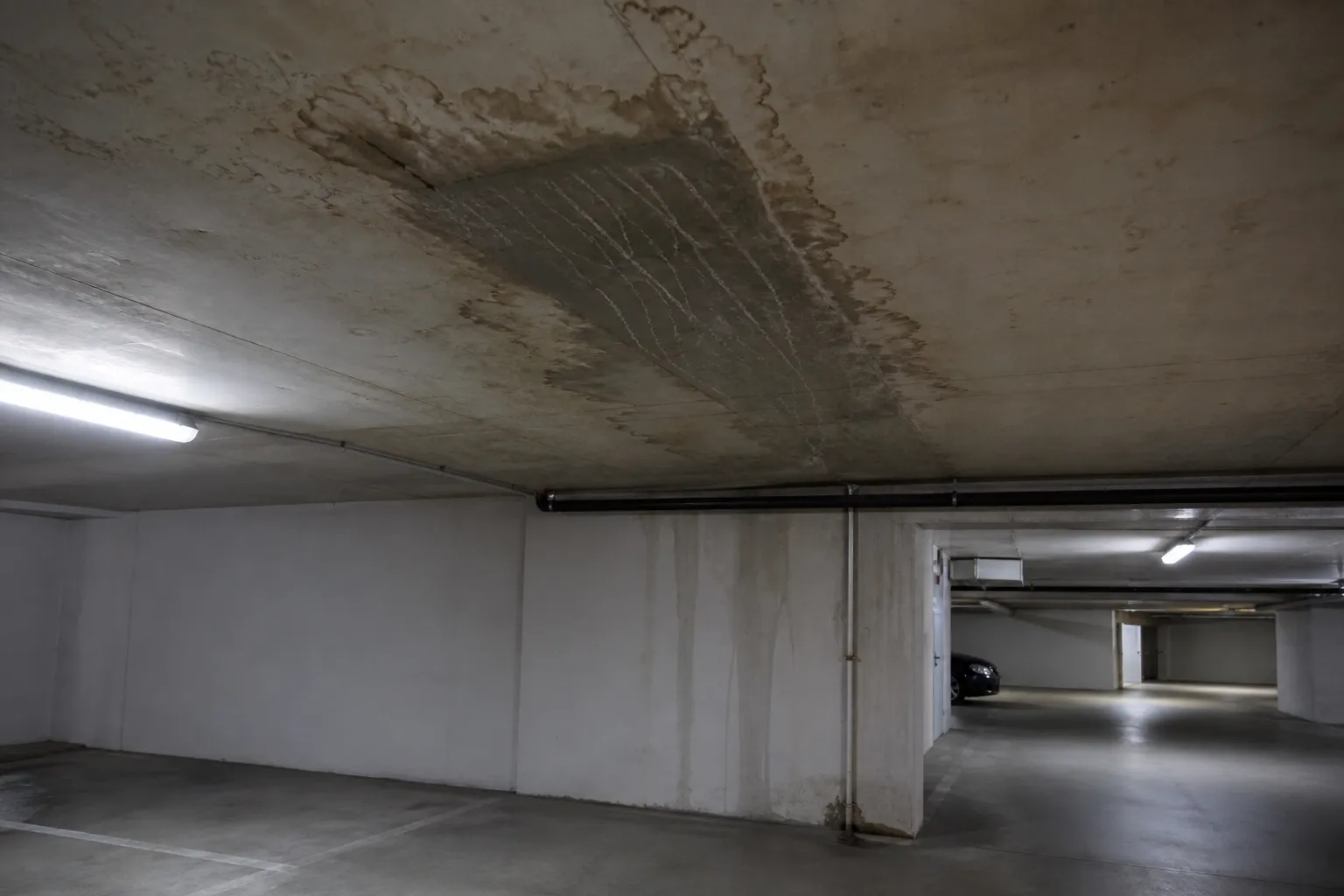Parking souterrain de résidence avec trace d’infiltration au plafond