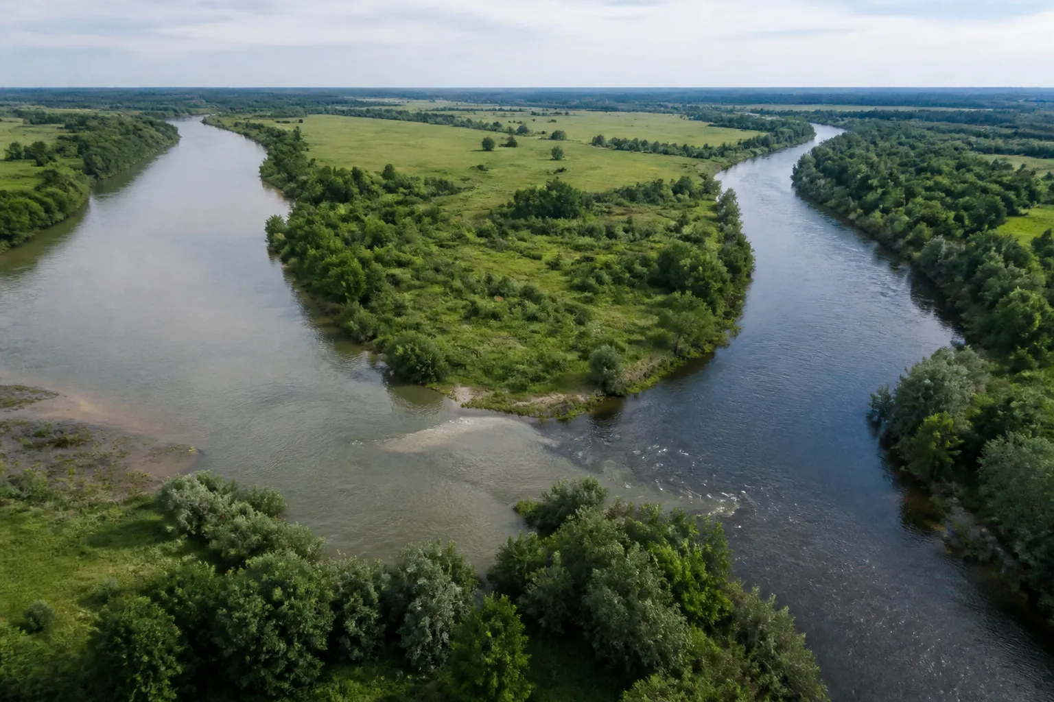 Confluence de deux rivières dans une plaine verte