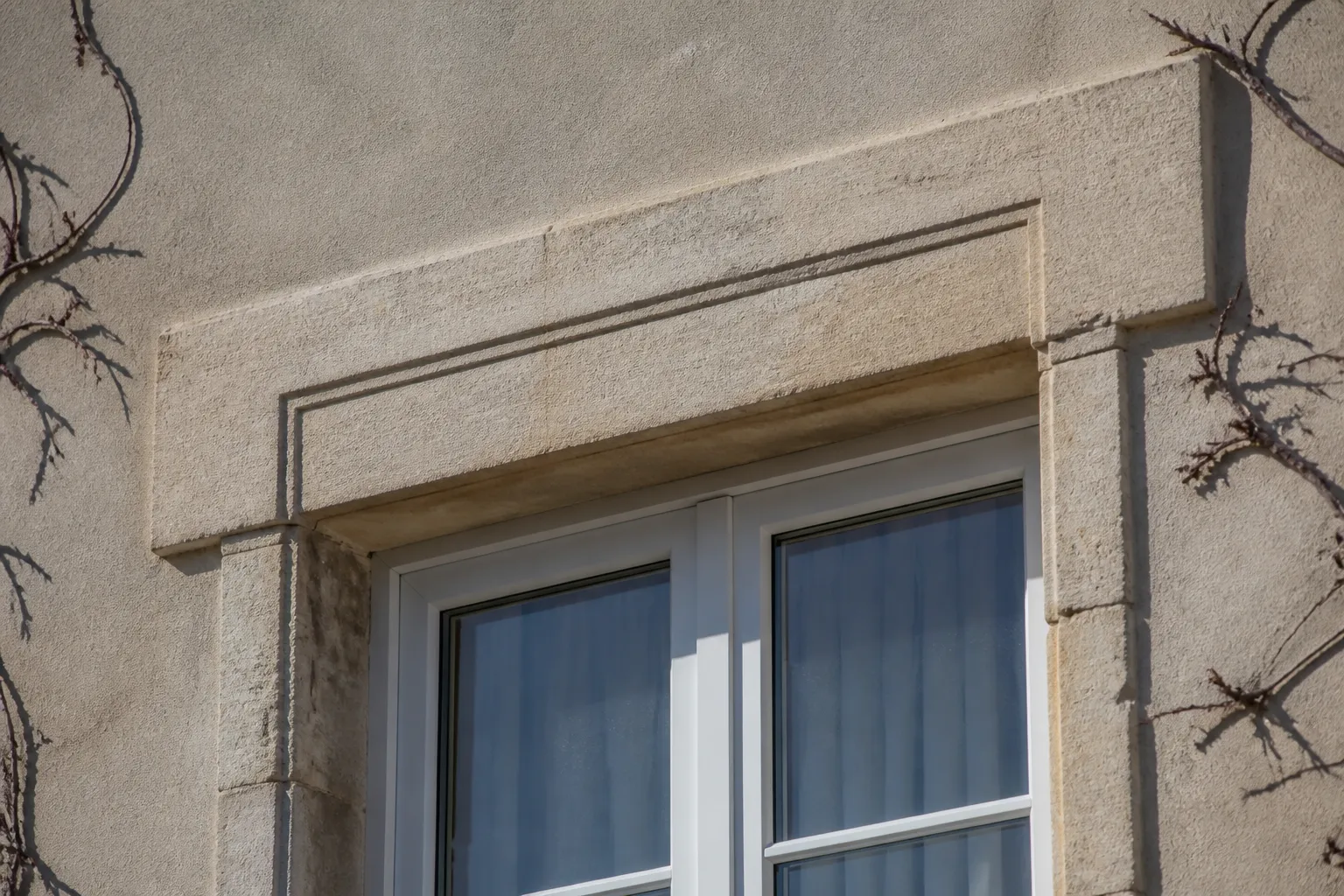 Linteau et encadrement de fenêtre en pierre sur une maison ancienne