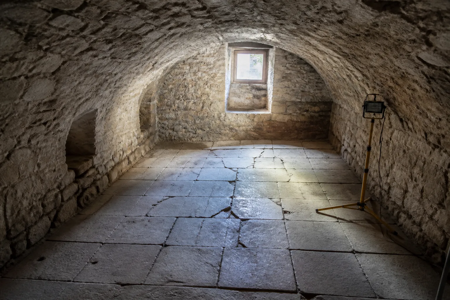 Sous-sol en pierre d’une maison ancienne avec plancher bas fissuré