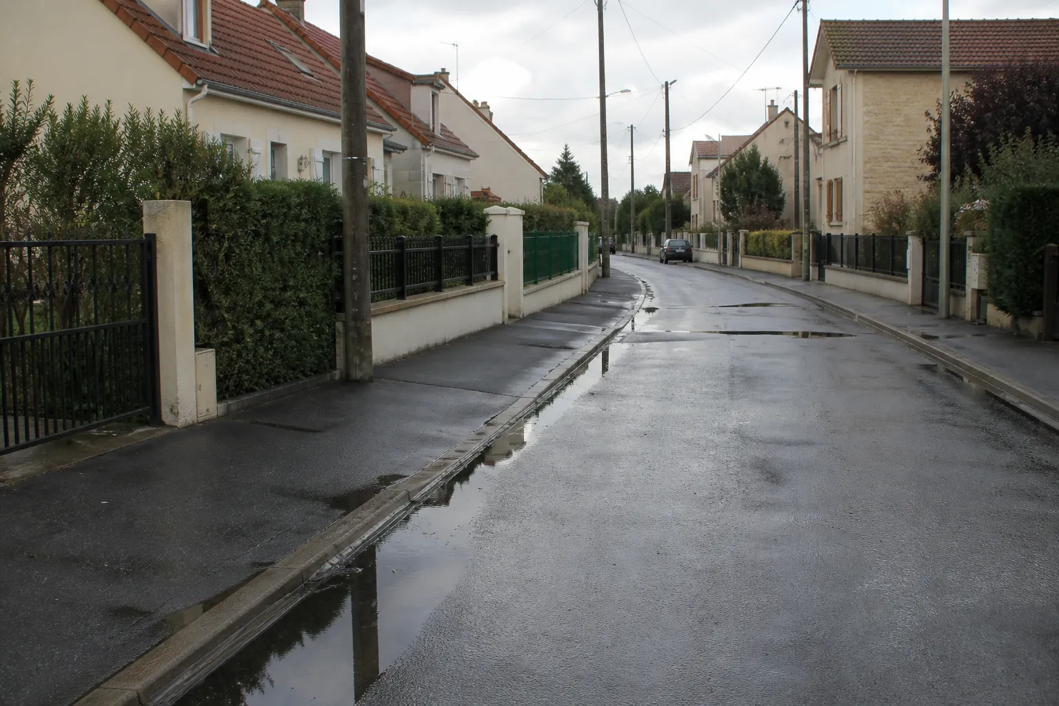 Rue pavillonnaire après une averse avec caniveaux en eau