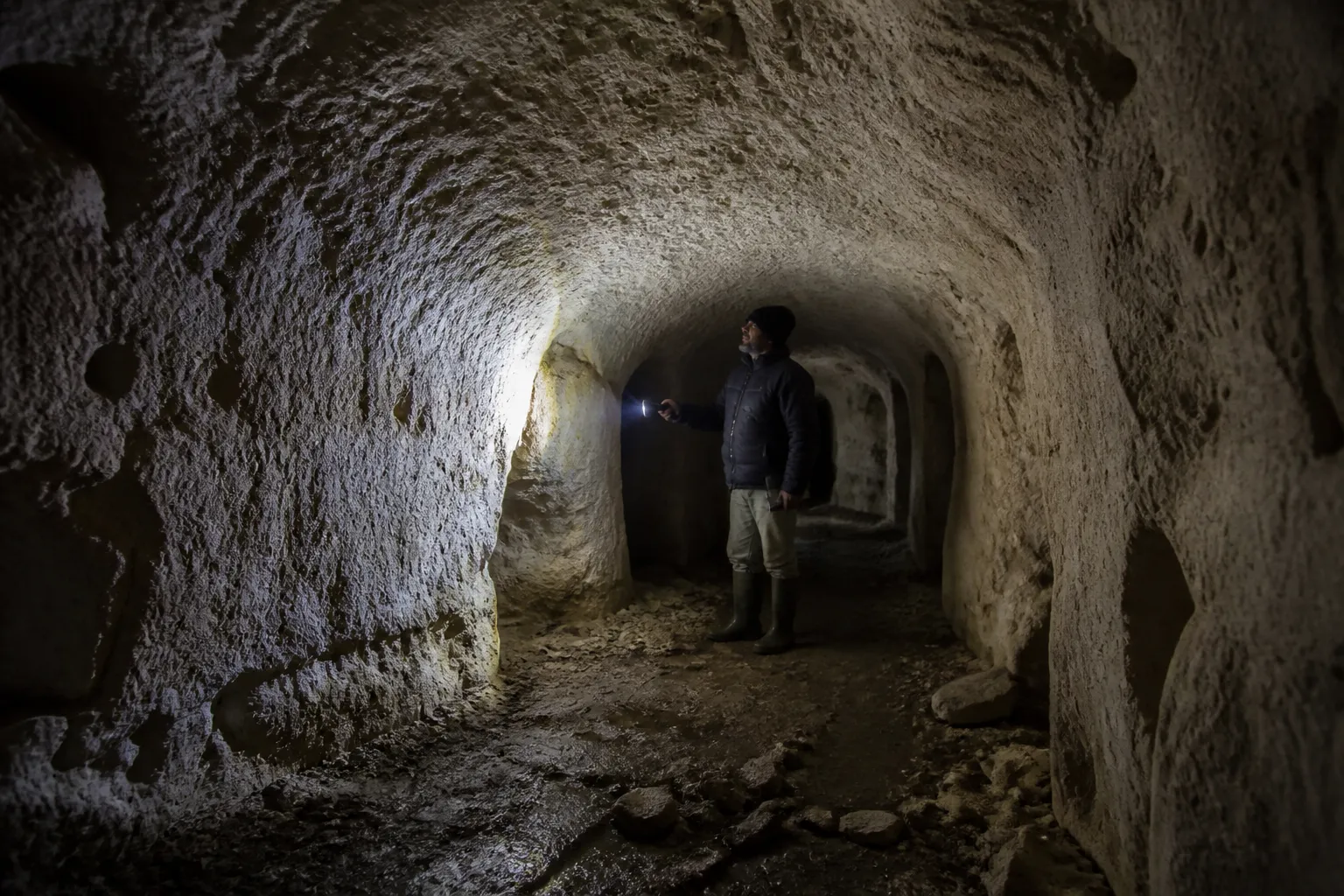 Cave voûtée creusée dans le calcaire, inspectée à la lampe lors d’un bilan avant achat