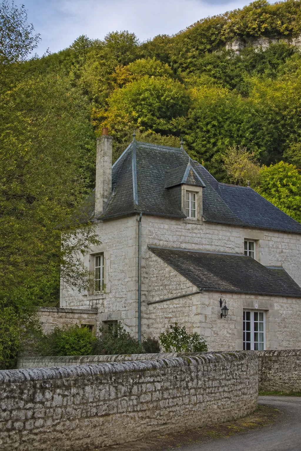 Maison ancienne en pierre claire au pied d’un coteau boisé, illustration bilan avant achat à Saint-Cyr-sur-Loire