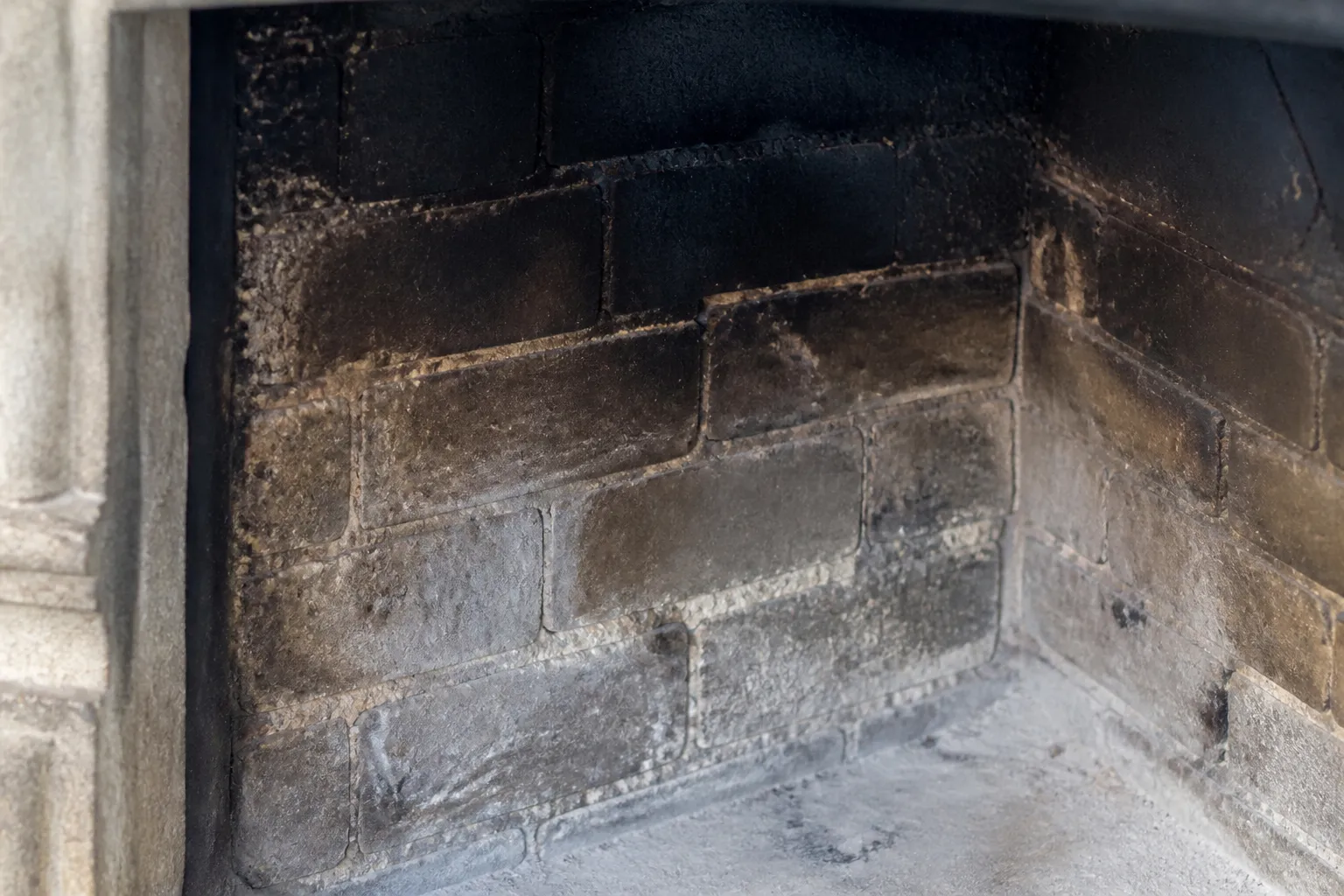 Intérieur d’un foyer de cheminée ancien avec briques réfractaires