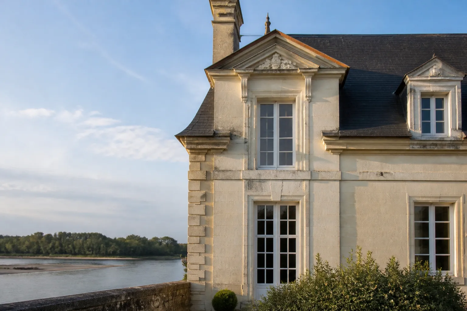 Façade de maison ancienne en tuffeau blanc avec toiture en ardoise dans le Val de Loire