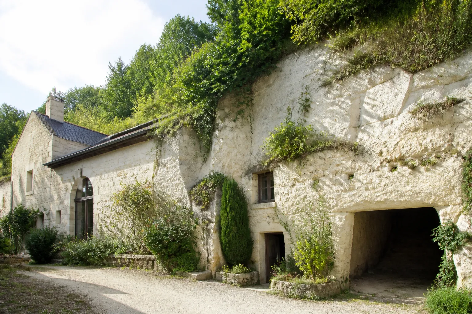 Maison en tuffeau adossée à un coteau calcaire avec entrée de cave creusée
