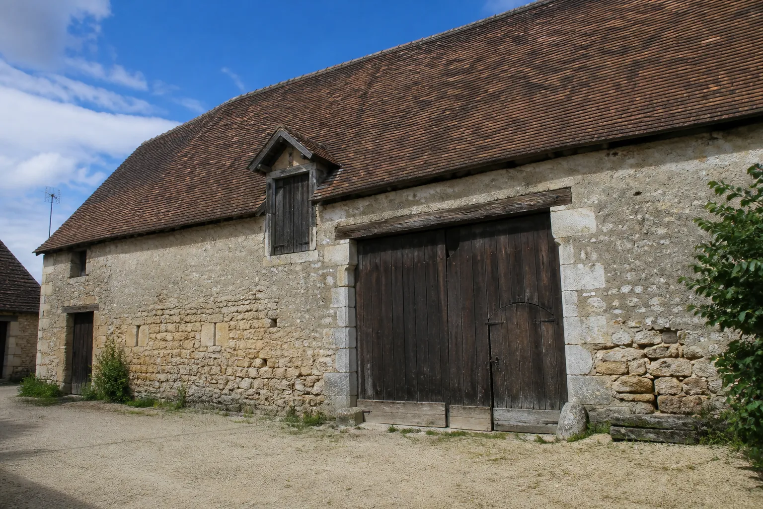 Grange à portail charretier dans un corps de ferme du Berry