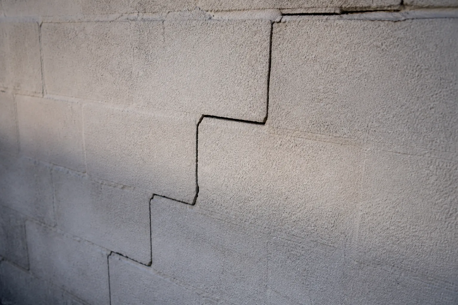 Fissure en escalier dans les joints d’un mur de maison