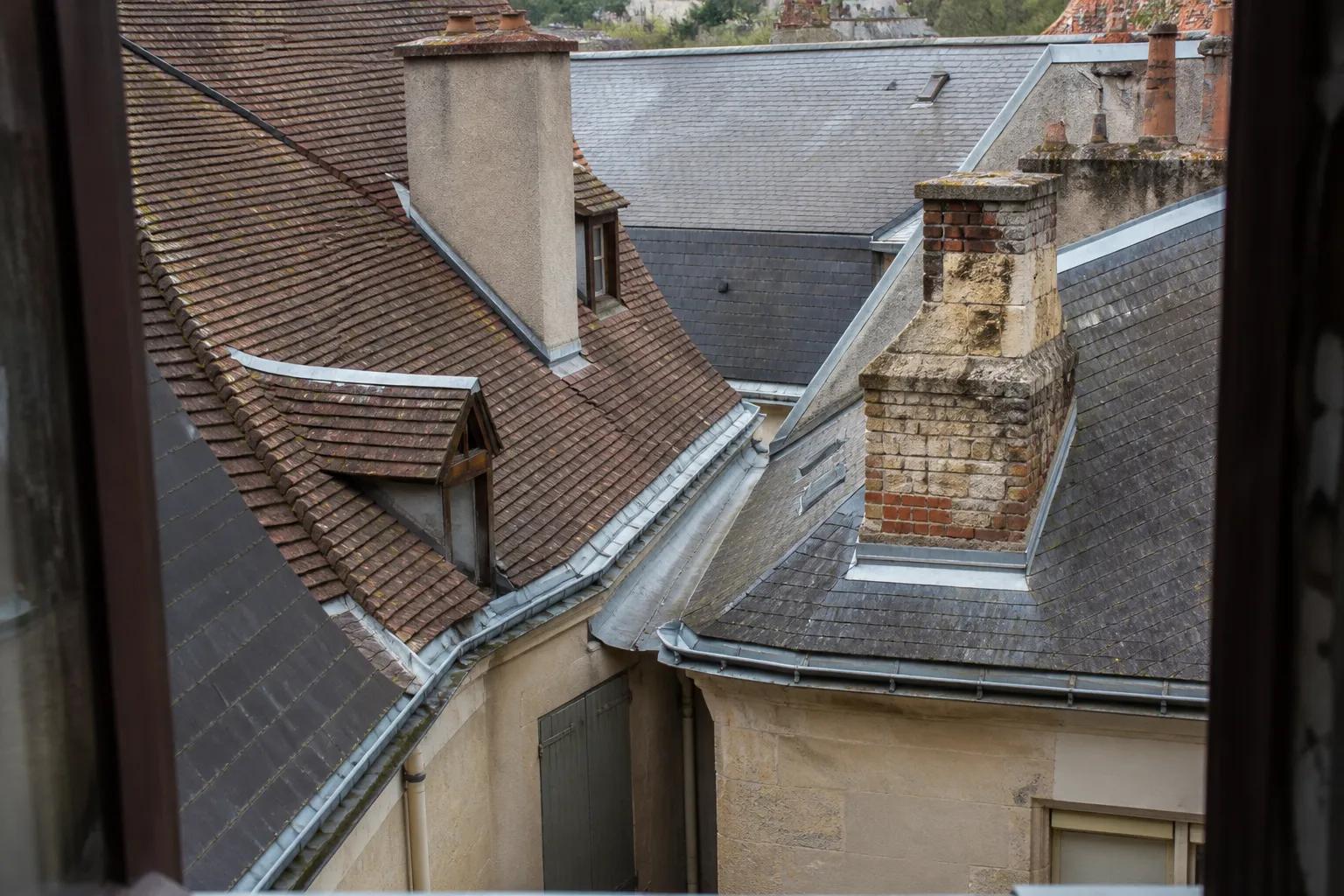 Toitures imbriquées de maisons de village avec chéneau et souches de cheminée communes