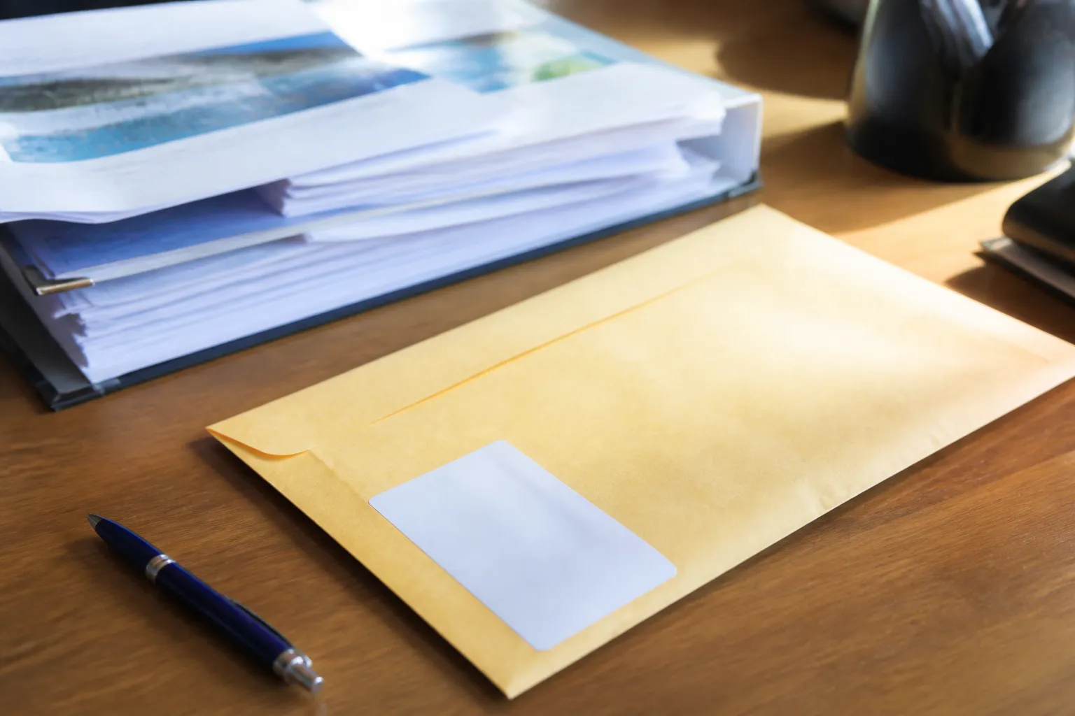 Lettre recommandée et accusé de réception posés sur un bureau à côté d’un stylo